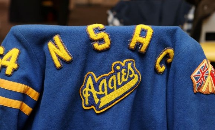 a blue sports jacket across the back of a chair with NSAC Aggies in yellow