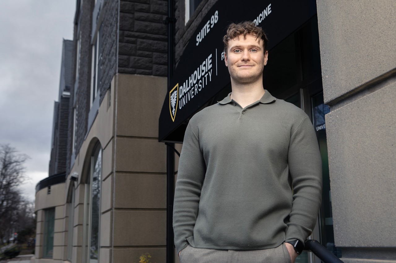 Koscak stands confidently with hands in pockets outside the entrance to one of Dal's medical campus buildings.