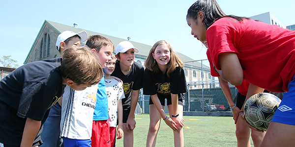 Children engaged in a lively soccer game on a vibrant green field, showcasing teamwork and enthusiasm.