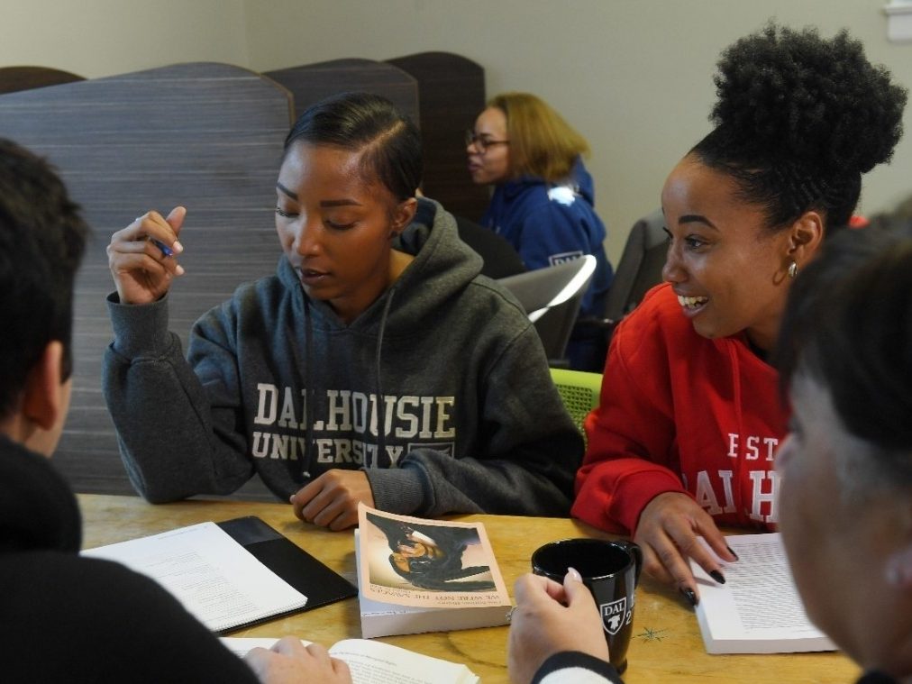 Group of students sitting around a table with open books.